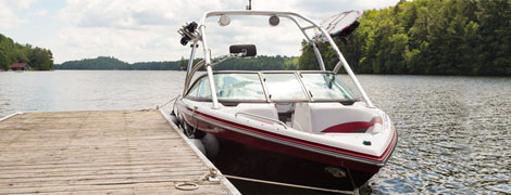 Photo d'un bateau à moteur rouge et blanc amarré sur l'eau